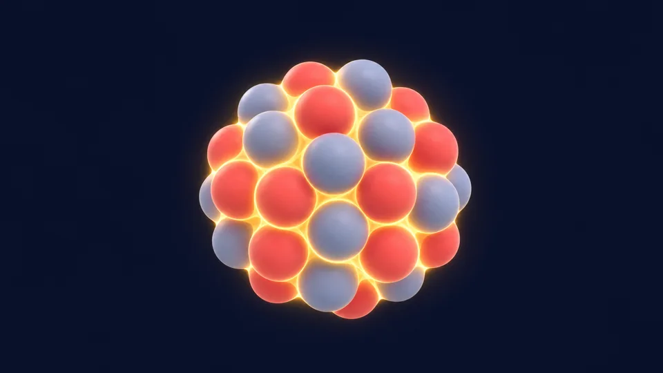 A cluster of red protons and grey neutrons packed into a glowing nucleus
